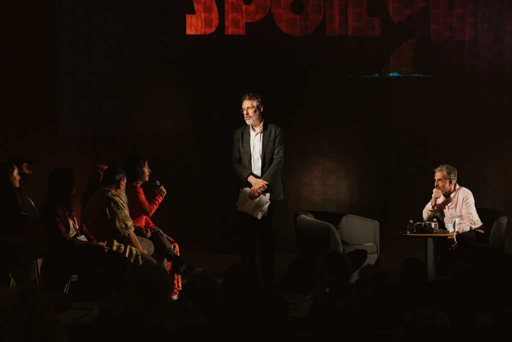 Ira Glass and Edgar Keret take a question from a woman with a microphone sitting onstage