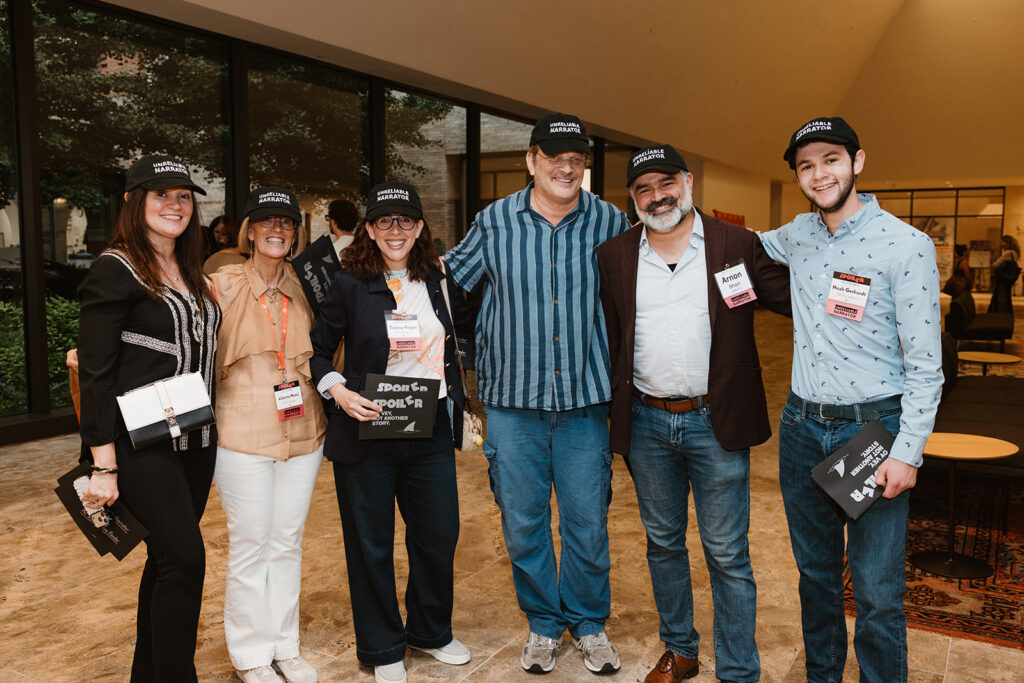 6 MFA in Creative Writing students wearing "Unreliable Narrator" baseball caps